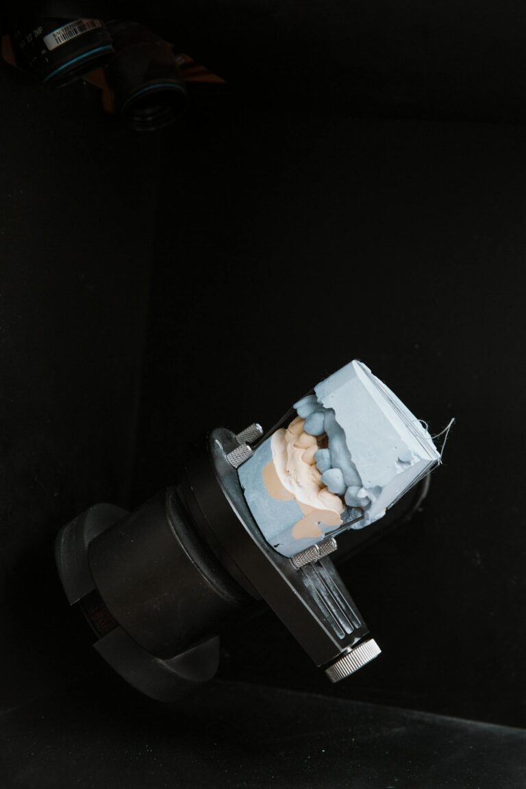 Dental mold displayed on apparatus in a lab setting; suitable for dentistry concept use.
